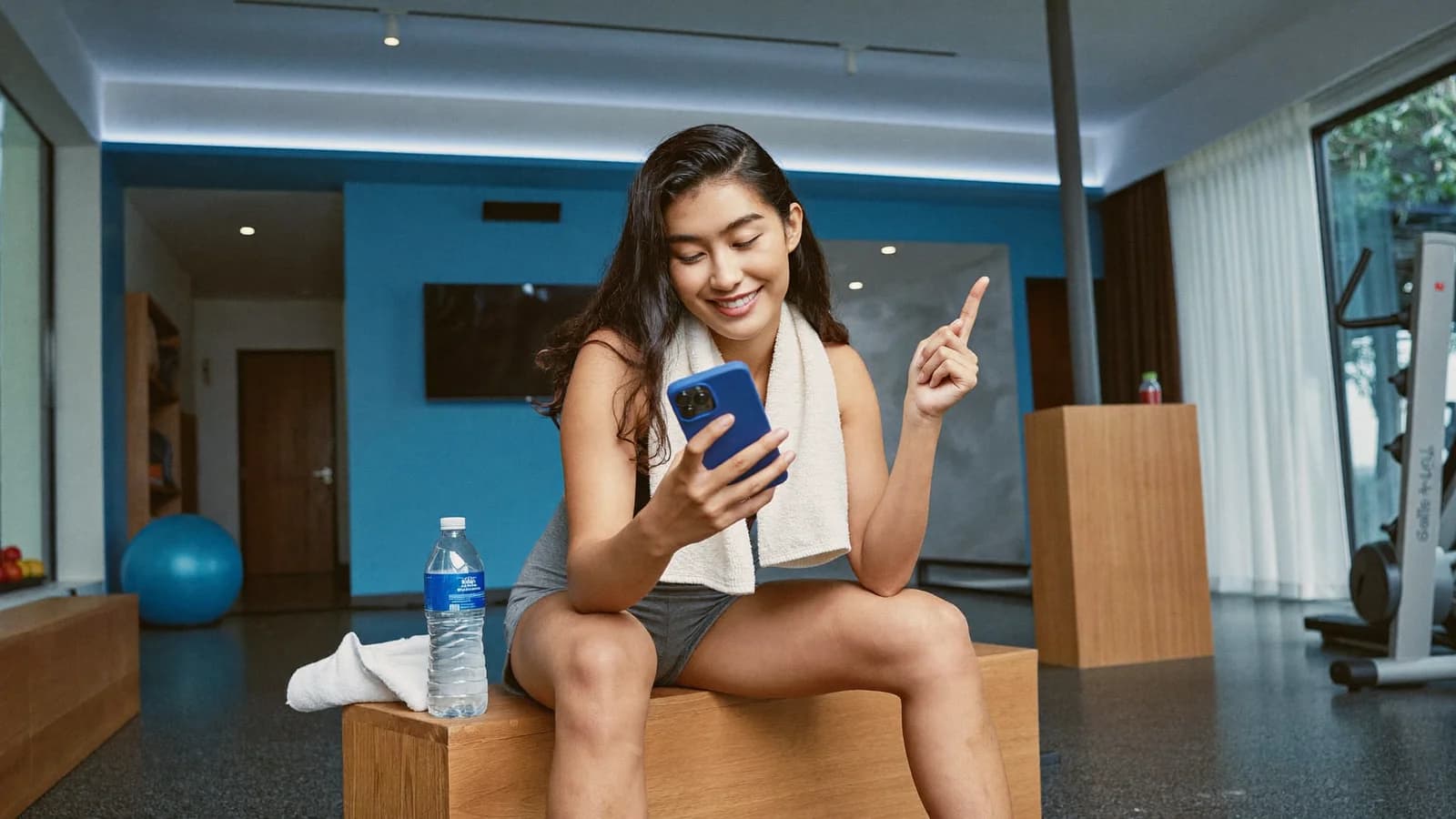 Member checking her workout results on the phone after class